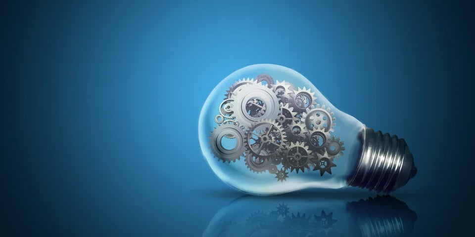 Close up of light bulb with gear mechanism inside isolated on dark blue background